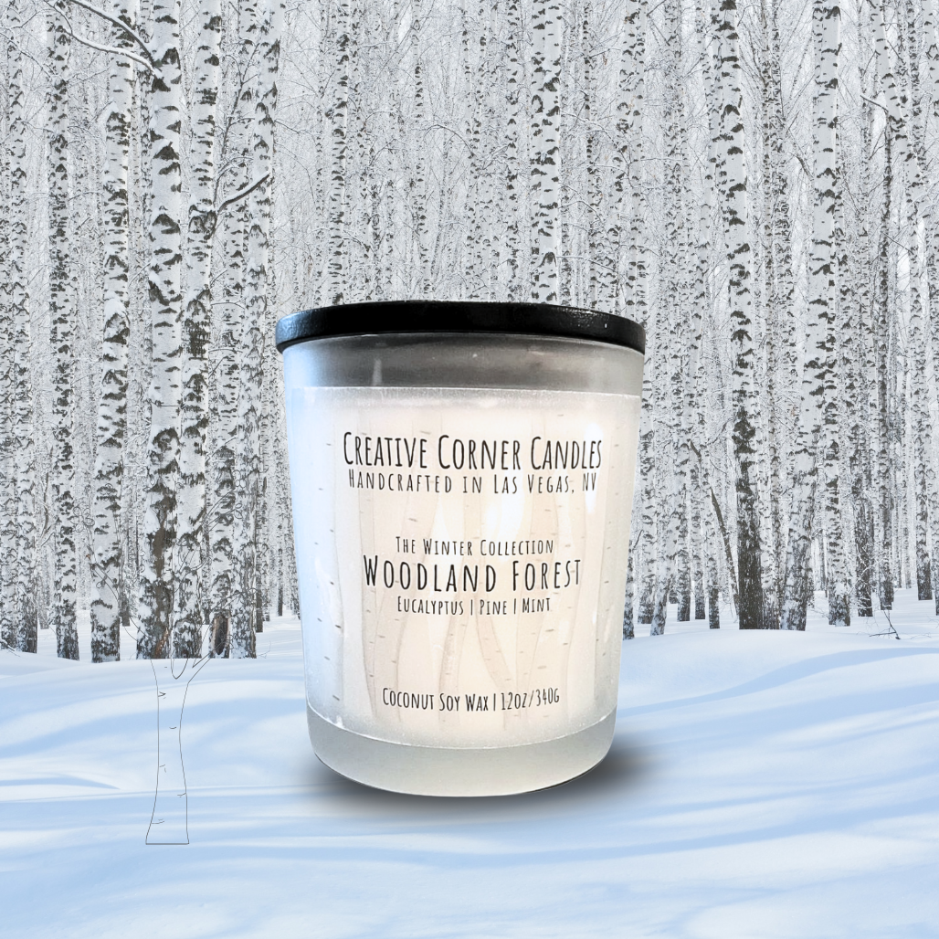 Candle labeled 'Woodland Forest' in a snowy forest setting