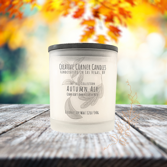 Autumn Air fall candle with cedar leaf, amber, and earthy musk scent in coconut soy wax, hand-drawn label illustration of autumn leaves.