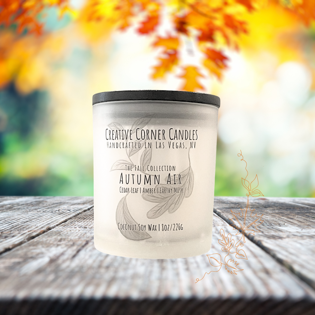 Autumn Air fall candle with cedar leaf, amber, and earthy musk scent in coconut soy wax, hand-drawn label illustration of autumn leaves.