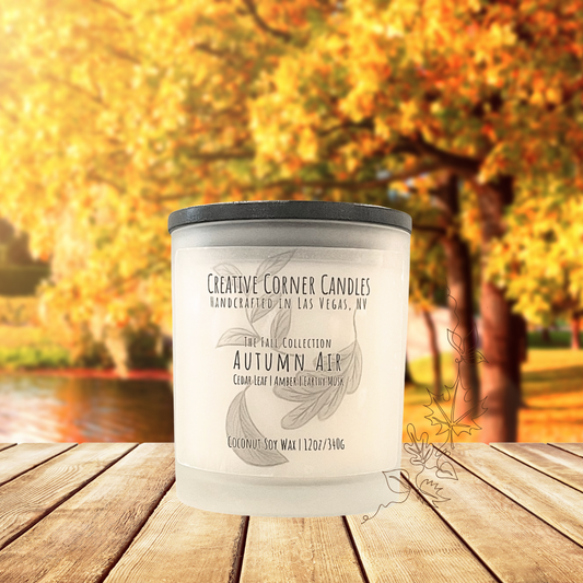 Autumn Air fall candle with cedar leaf, amber, and earthy musk scent in coconut soy wax, hand-drawn label illustration of autumn leaves.