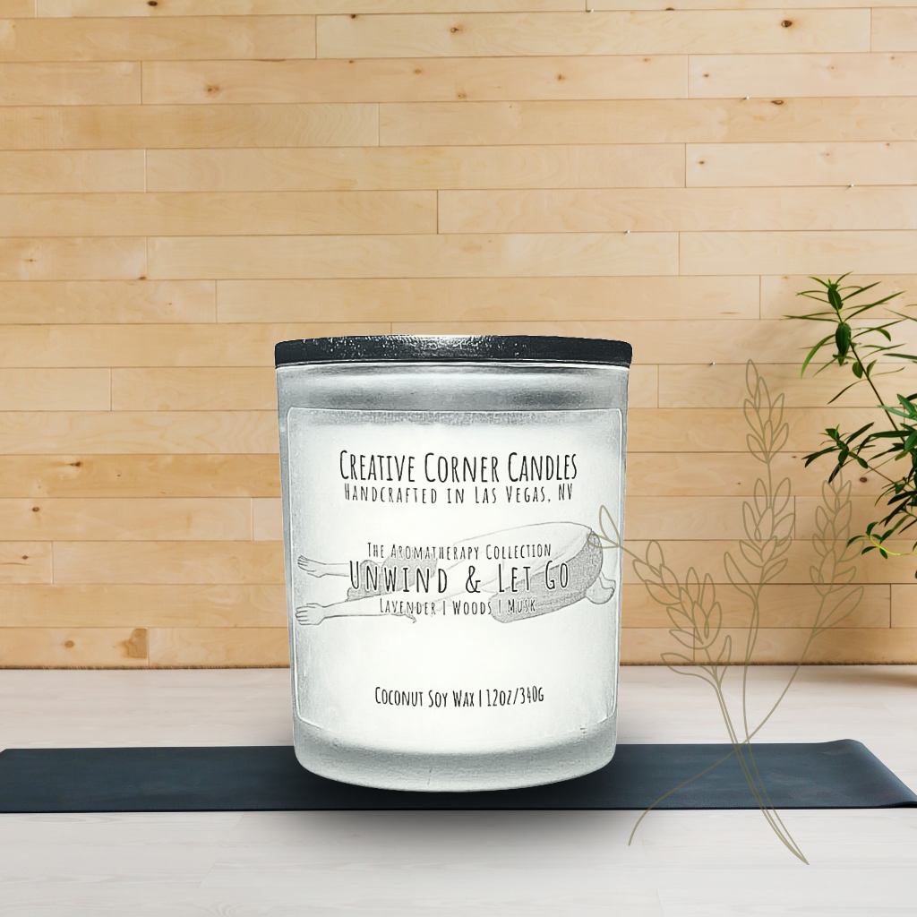 Unwind and Let Go handcrafted candles with a soothing aroma and a label featuring a hand-drawn illustration of a woman doing a child yoga pose