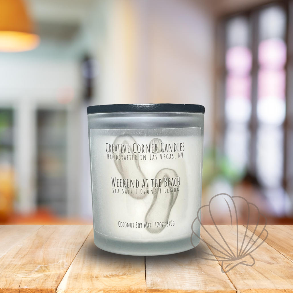 Weekend at the Beach handcrafted candles with a breezy, ocean-inspired scent and a label featuring a hand-drawn illustration of a beach scene