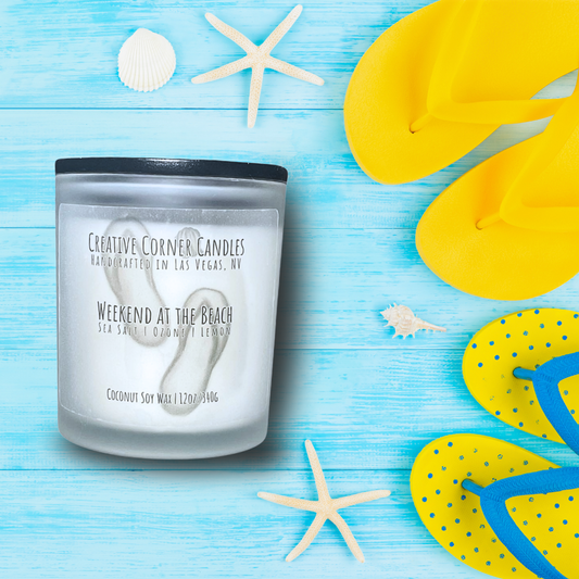 Weekend at the Beach handcrafted candles with a breezy, ocean-inspired scent and a label featuring a hand-drawn illustration of a beach scene