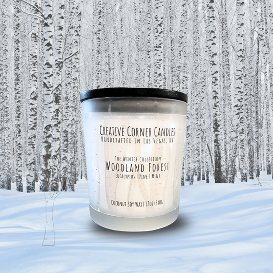 Candle labeled 'Woodland Forest' in a snowy forest setting